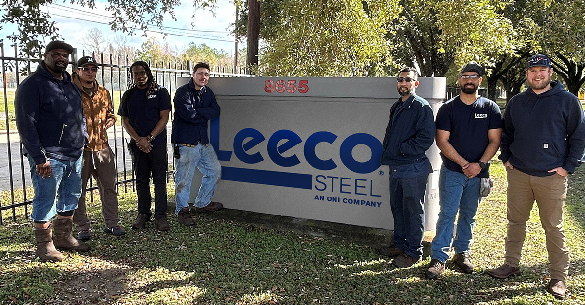 Leeco's Houston team stand in front of Leeco sign